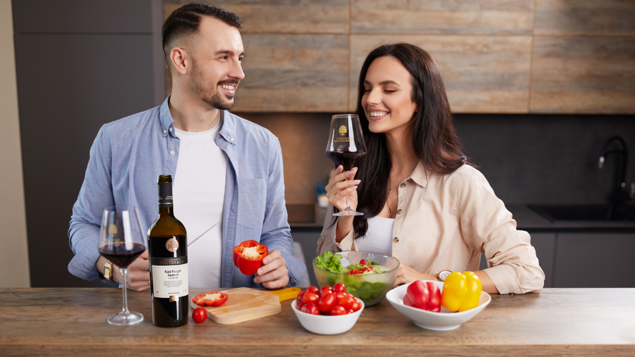 Degustare de vin rosu într-un ambient modern, cuplu relaxat la masa.