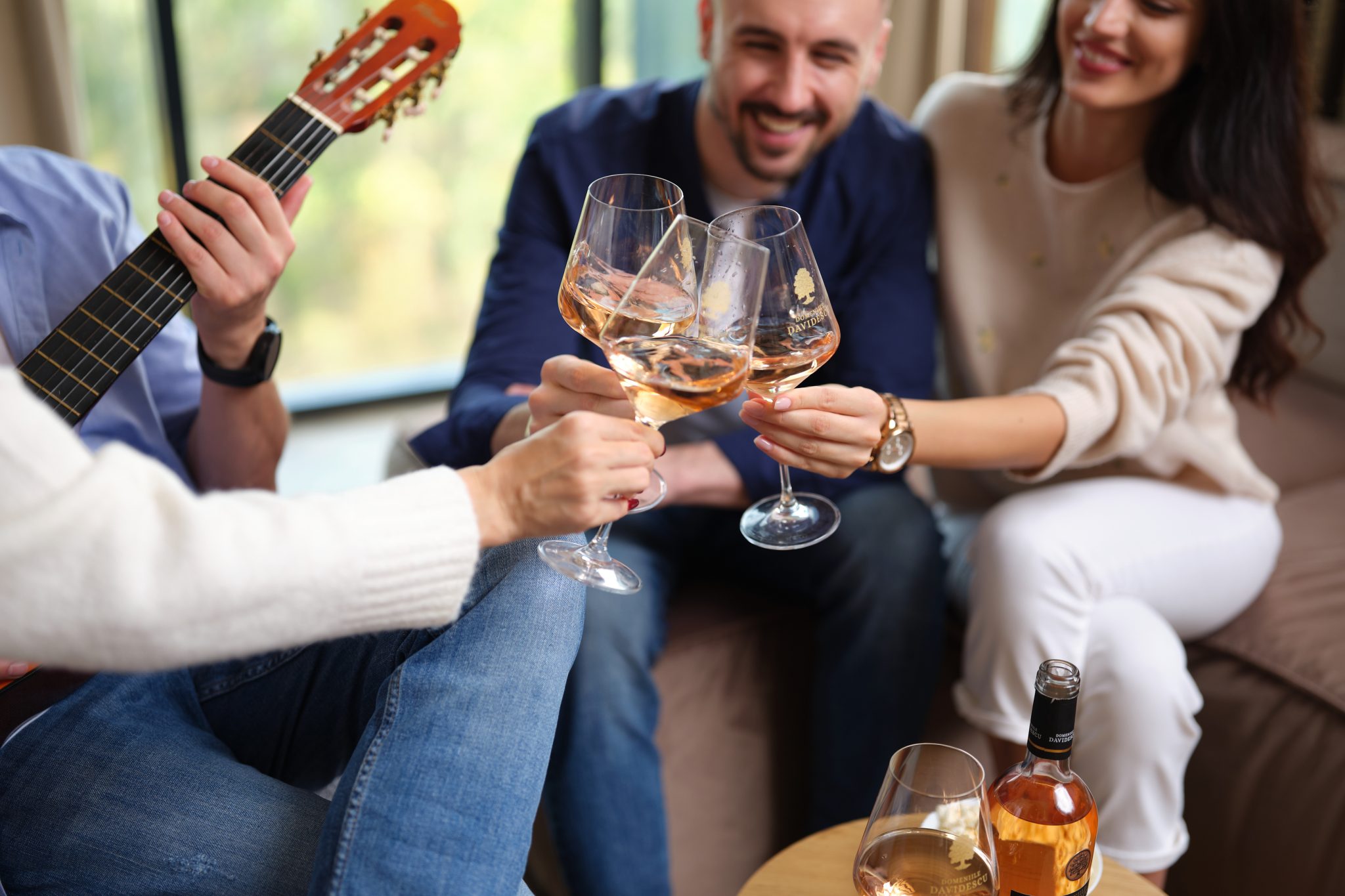 prieteni pe o banca, ciocnind pahare de vin rose domeniile davidescu