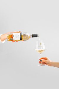 un pahar de vin in care se toarna rose din sticla